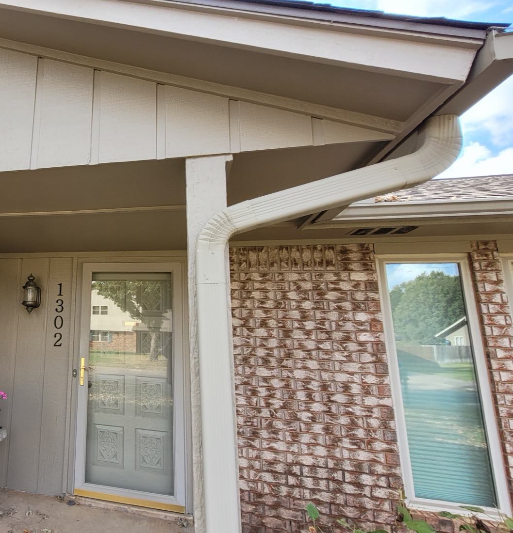 Finished seamless gutter and downspout installation on a brick home